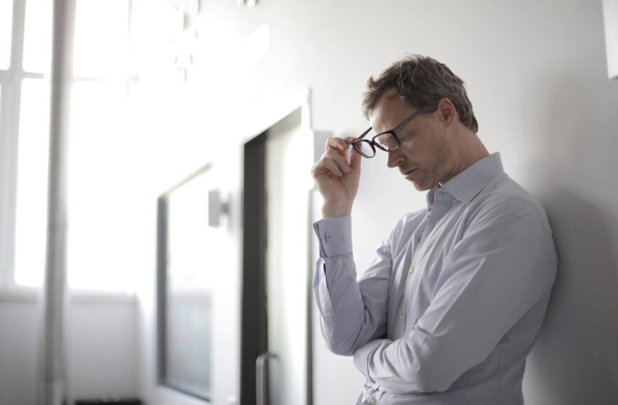 photo of man holding black eyeglasses