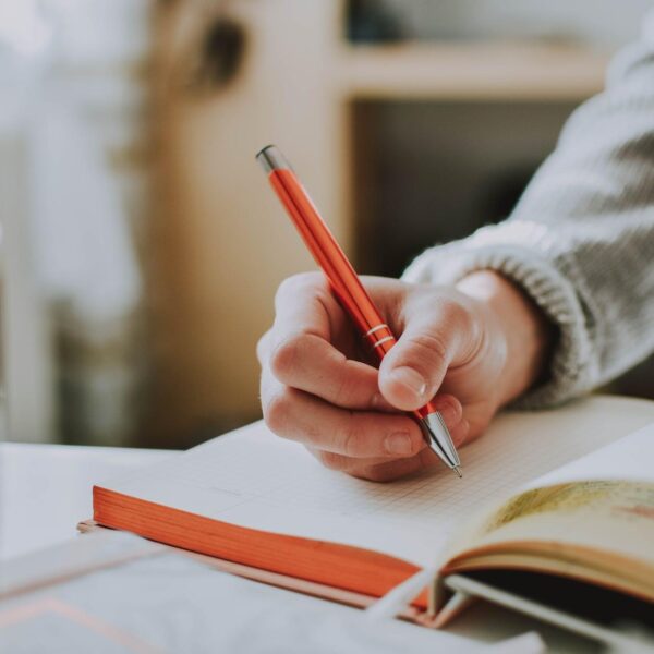 person holding orange pen