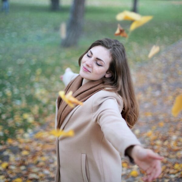 woman open arms while closed eyes smiling photo